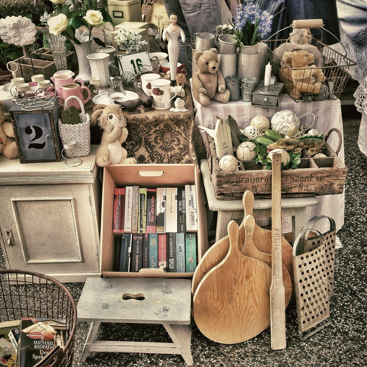 Flohmarktstand mit Büchern, Geschirr und alten Haushaltsgegenständen