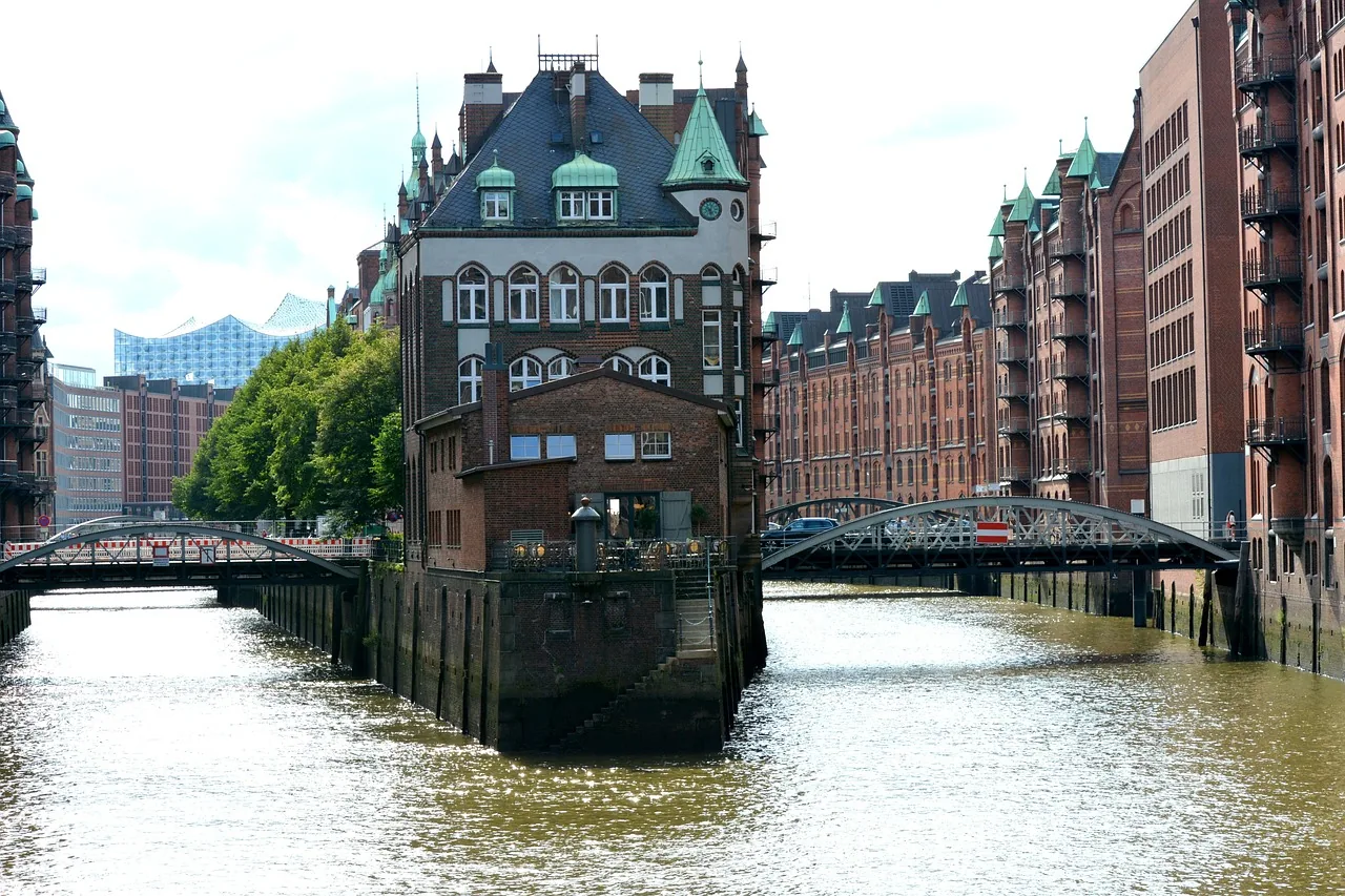 Hamburger Speicherstadt mit Fleeten, historischen Backsteingebäuden und der Elbphilharmonie im Hintergrund