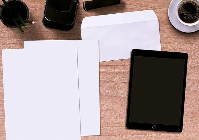 Briefe und Tablet auf einem Schreibtisch für digitalen und klassischen Postservice